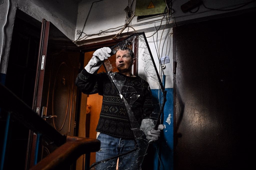 Mann mit zerbrochenem Fenster seines Hauses nach einem Beschuss nahe der ostukrainischen Stadt Lugansk am 22. Februar 2022, einen Tag nachdem Russland die Separatistenrepubliken in der Ostukraine anerkannt hatte.