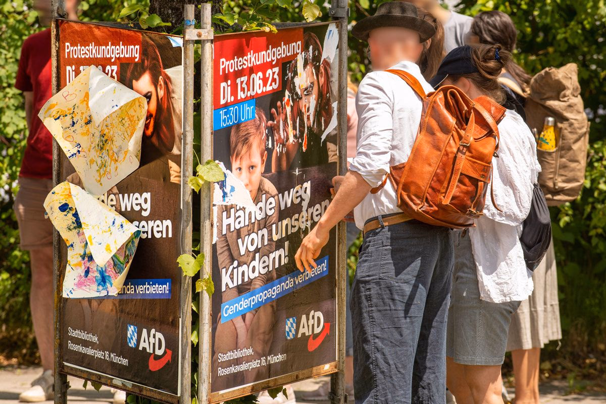 Transfeindliches AfD-Plakat, das von Passant*innen zerrissen wird.